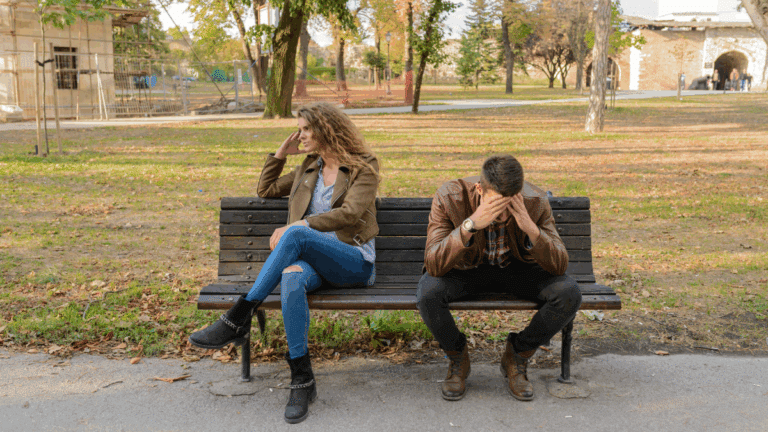 Couple sitting on bench breaking up